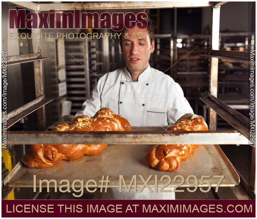 Photo of Baker with Freshly Baked Breads on a Tray